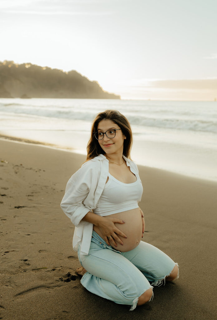 Pregnant mother sitting on the beach