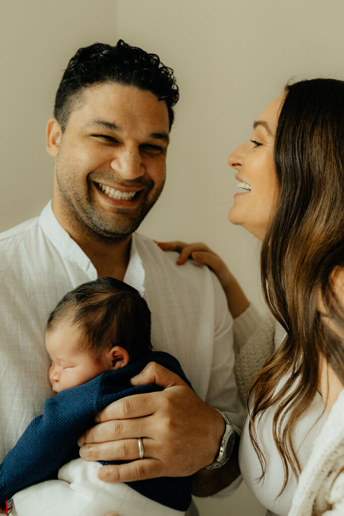 Mother, father, and baby boy during sweet at home newborn photography session in LA
