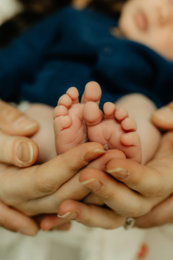 Mother and father holding newborns feet