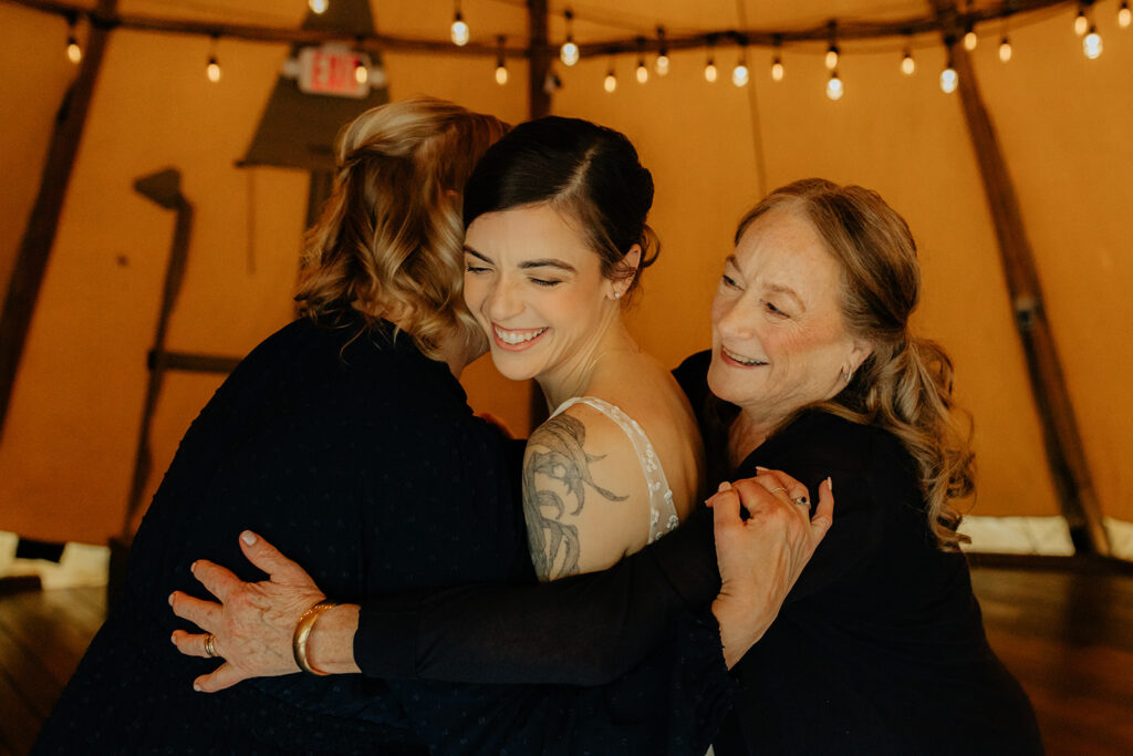 bride hugging with her mom and her grandma at her intimate outdoor wedding