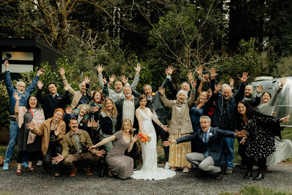 portrait of the bride and groom with their wedding guests at their intimate outdoor wedding