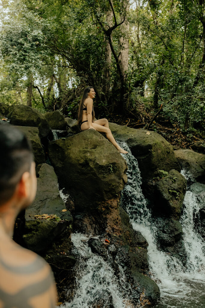 adventurous couple swing in a waterfall 