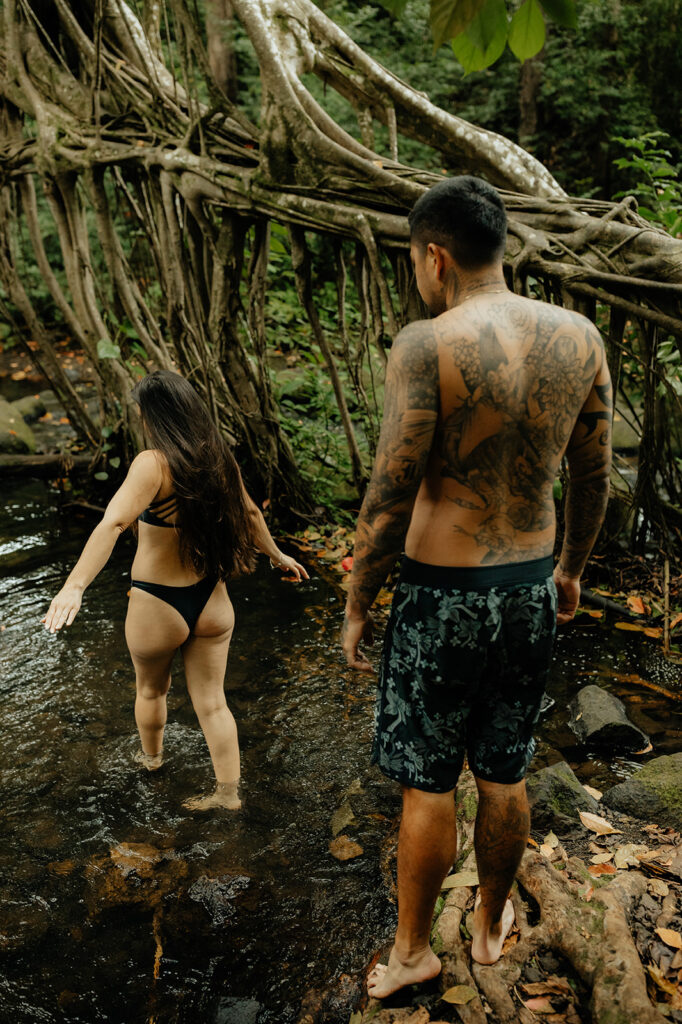 couple walking around one of oahu's waterfall