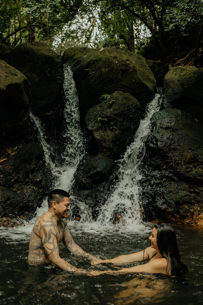couple playing in the waterfall 