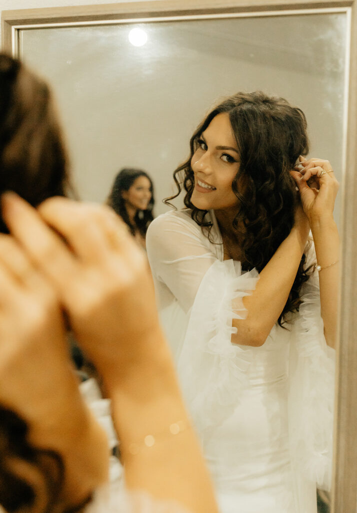 bride doing her hair before the ceremony