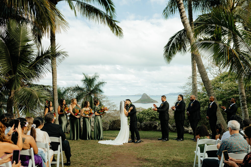 bride and groom kissing after their Colorful Eco-Friendly Wedding ceremony at Kualoa Ranch, HI