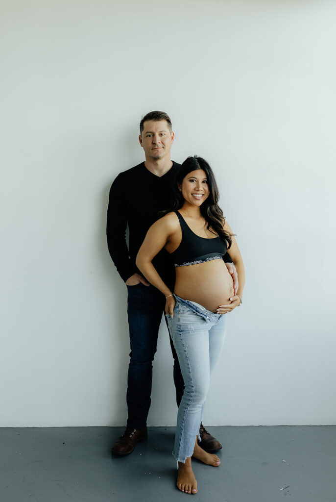mom and dad to be looking at the camera during their maternity session