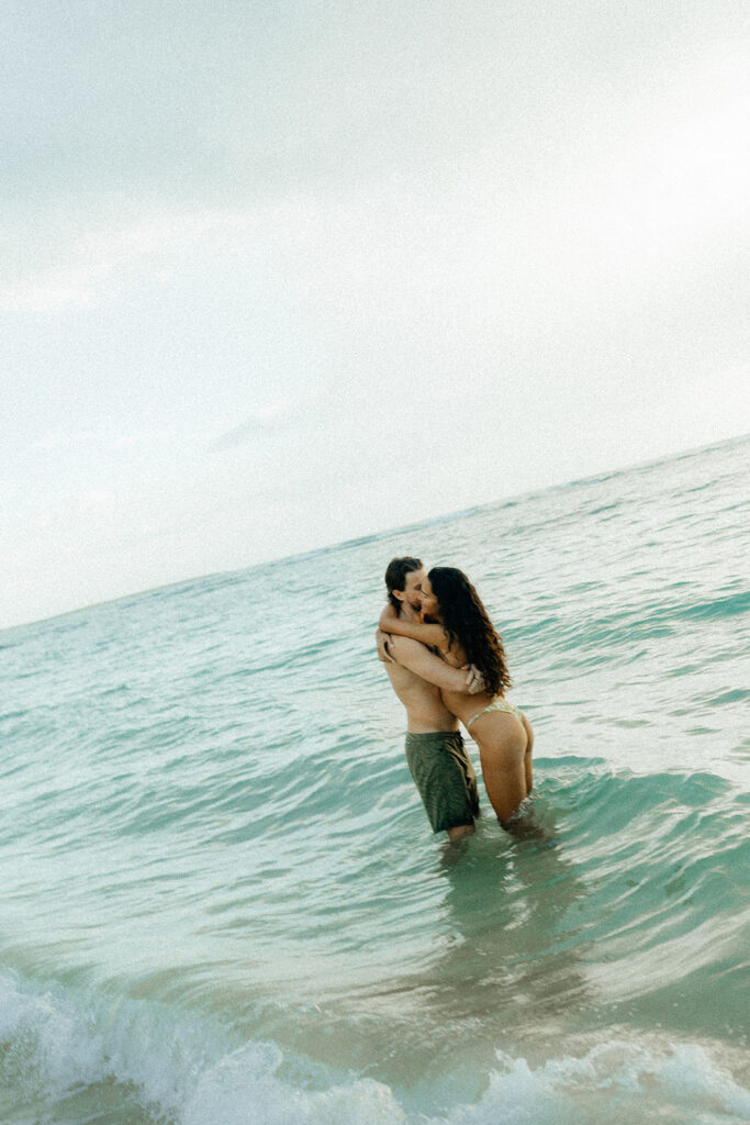 couple swimming during their Fun and Casual couple Session in Oahu, HI