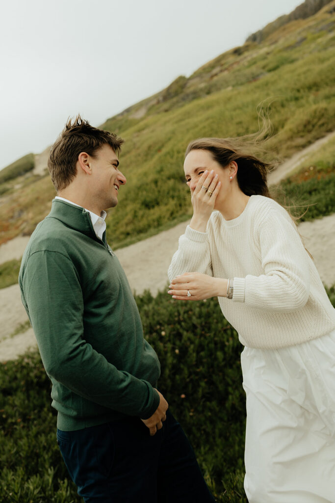 newly engaged couple laughing with each other 