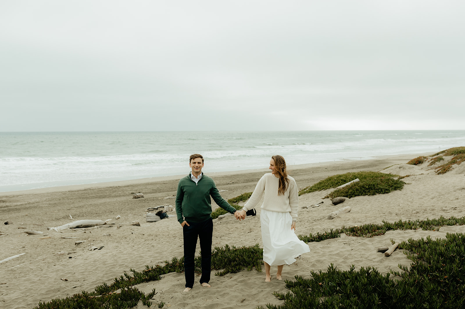 newly engaged couple holding hands during their beach engagement session