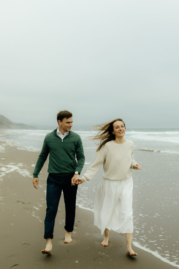 couple running around the beach during their photoshoot 