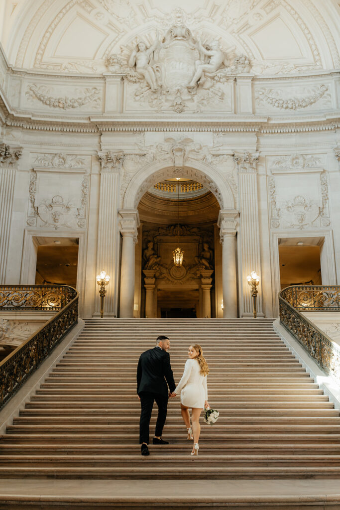 San Francisco City Hall Elopement couple walking up main staircase bride looking back