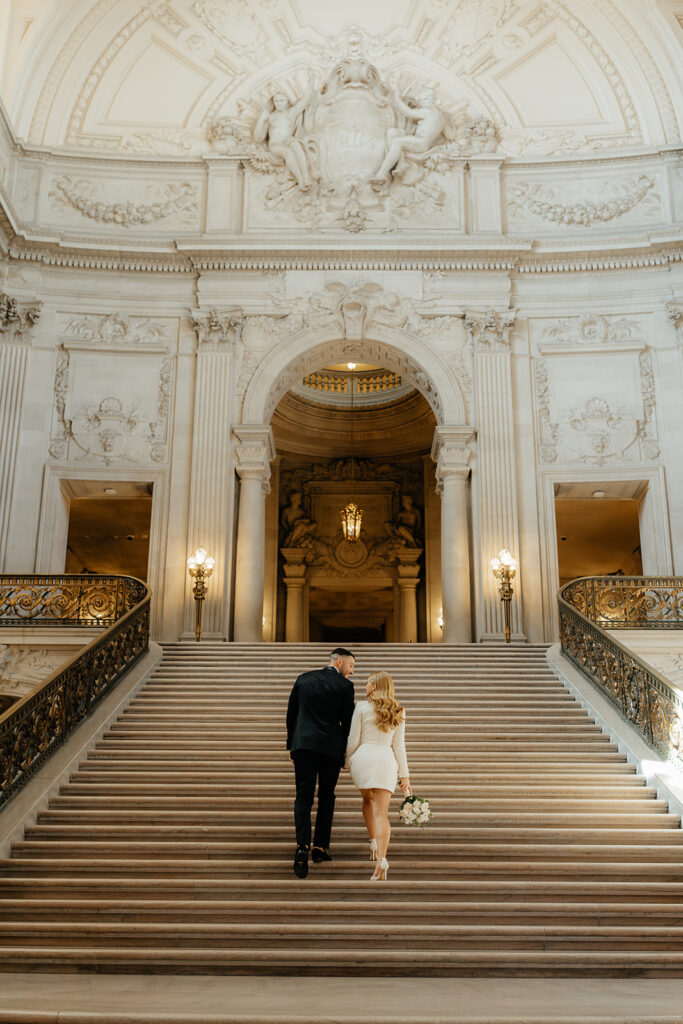 San Francisco City Hall Elopement couple walking up main staircase bride looking back