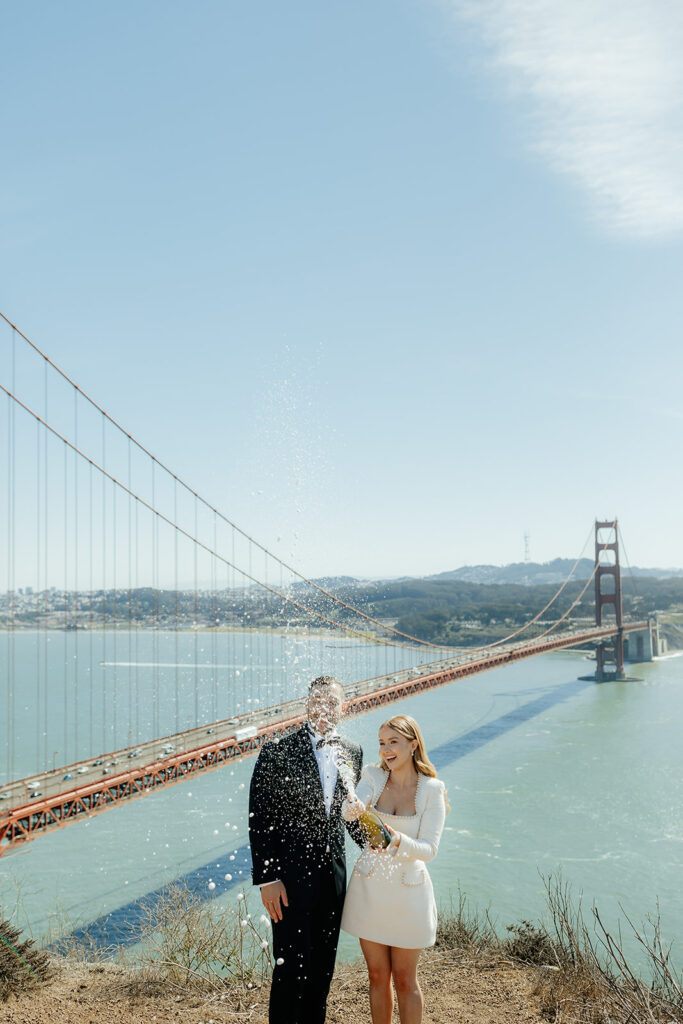 Elopement Couple at San Francisco Golden Gate bridge popping champagne