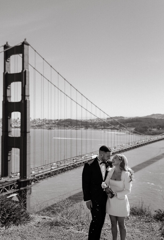 Elopement Couple at San Francisco Golden Gate bridge popping champagne