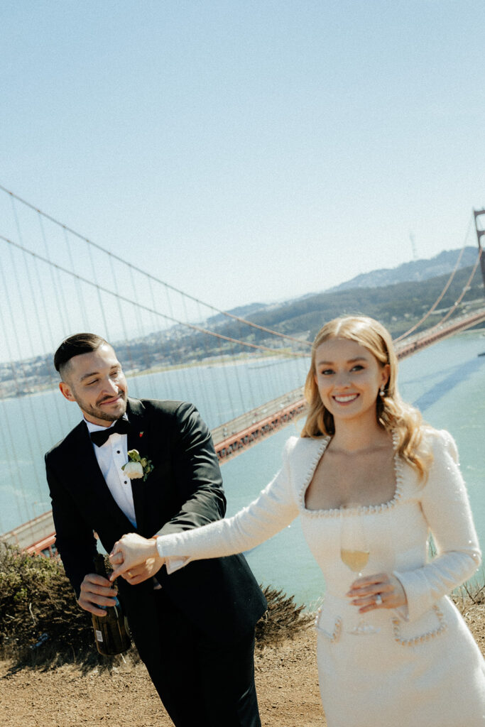 Elopement Couple at San Francisco Golden Gate bridge with champagne happy