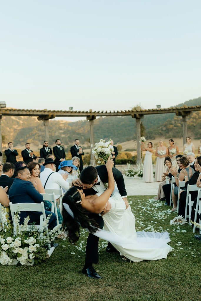 Clos LaChance Wedding ceremony bride and groom dip kiss 