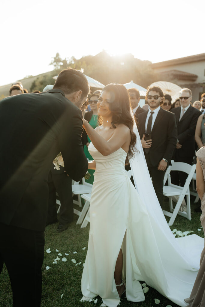 Clos LaChance Wedding ceremony groom kissing bride's hand