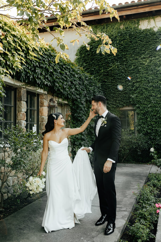 Clos LaChance Wedding - Bride and groom walking with groom holding dress