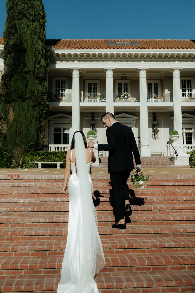 Grand island mansion wedding couple walking up front steps