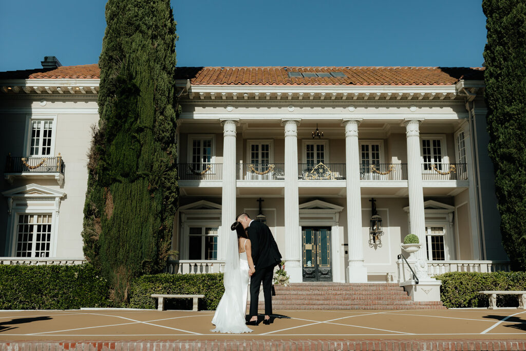 Grand island mansion wedding venue with couple kissing 