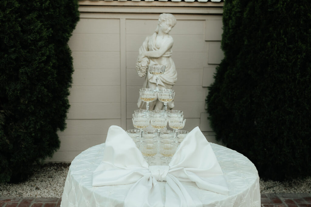 wedding champagne tower with vintage statue in background