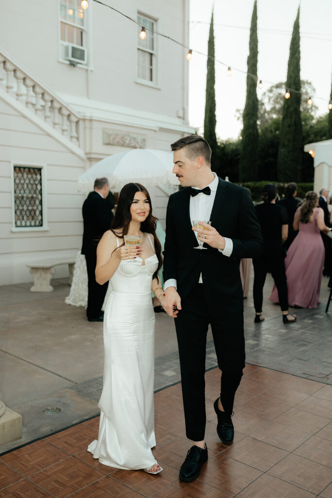 Grand island mansion wedding chic couple at cocktail hour holding drinks 