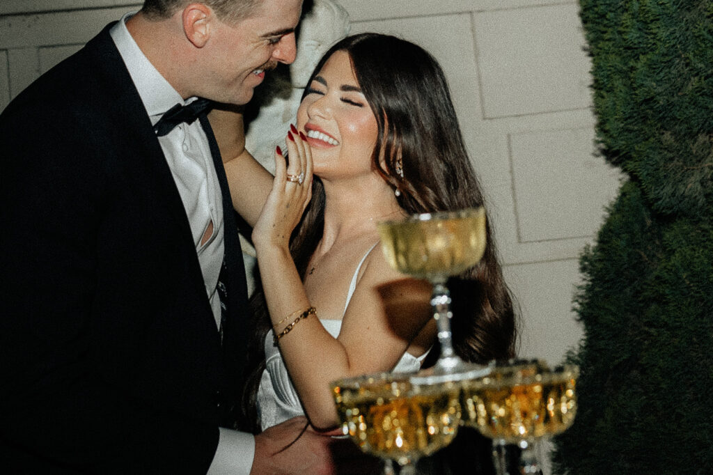 wedding chic couple in front of champagne tower